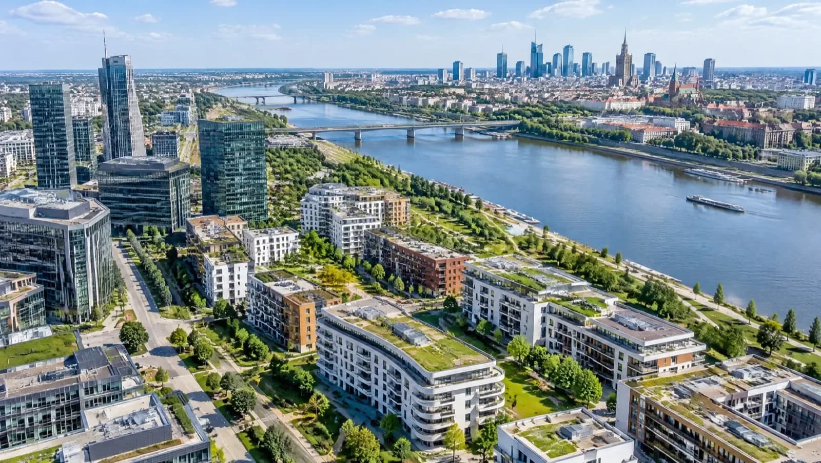 Widok z lotu ptaka na nowe osiedla i biurowce w dużym mieście nad rzeką